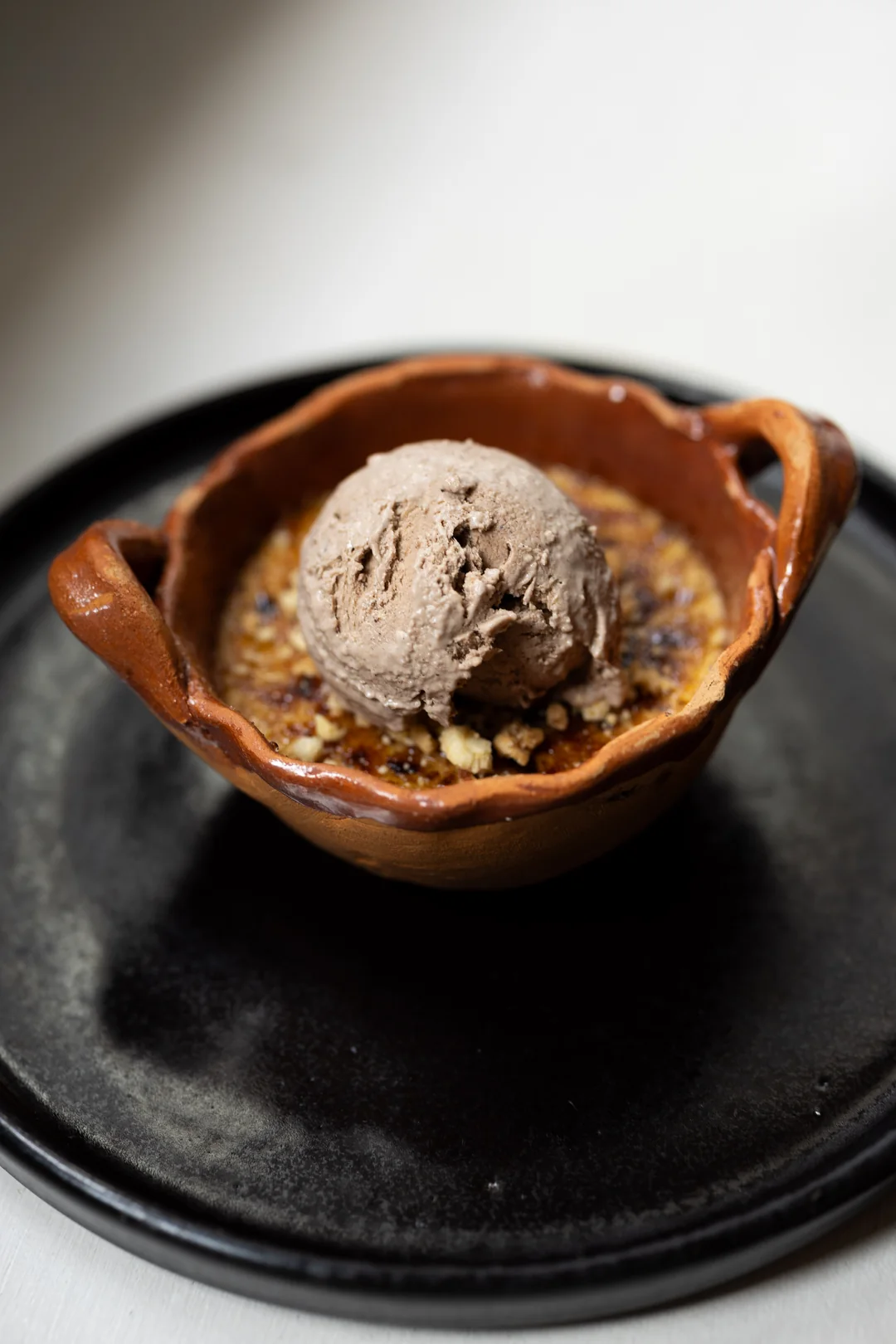 Postre servido con helado en una cazuela de barro